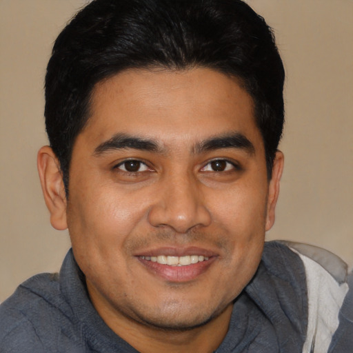 Joyful latino young-adult male with short  brown hair and brown eyes