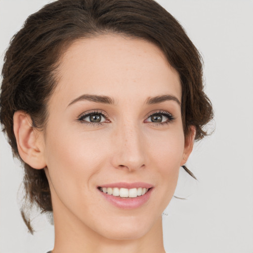 Joyful white young-adult female with medium  brown hair and green eyes