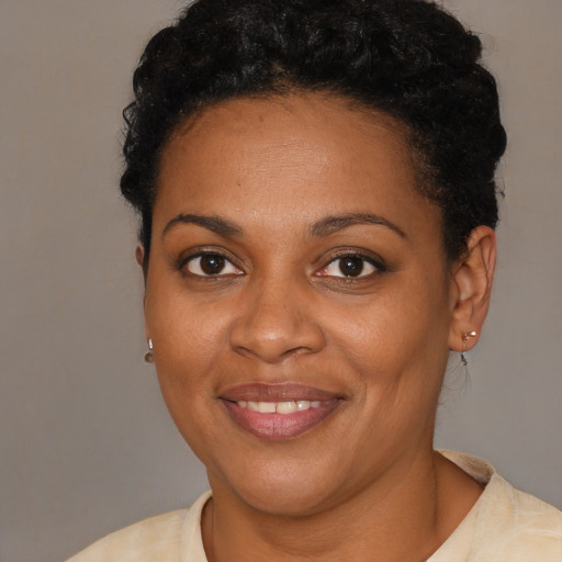 Joyful black young-adult female with short  brown hair and brown eyes