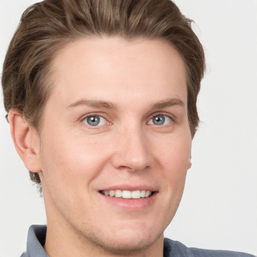 Joyful white young-adult male with short  brown hair and grey eyes