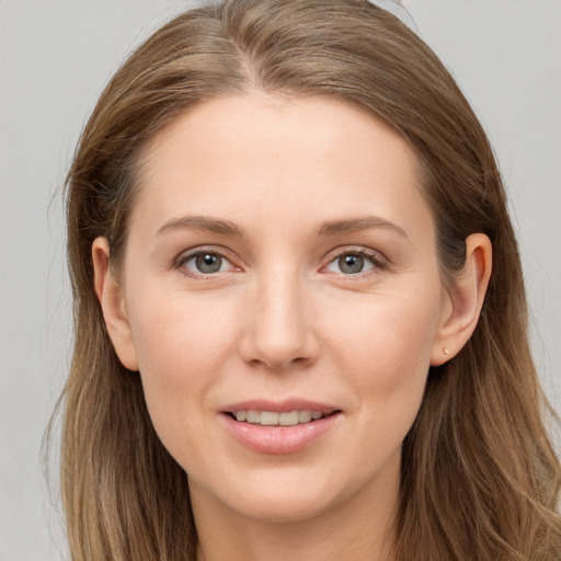 Joyful white young-adult female with long  brown hair and grey eyes