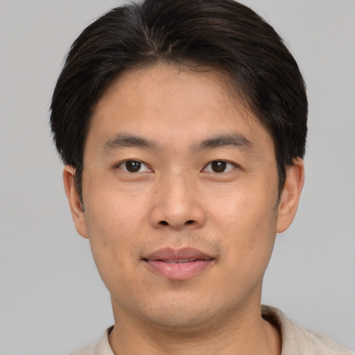 Joyful asian young-adult male with short  brown hair and brown eyes