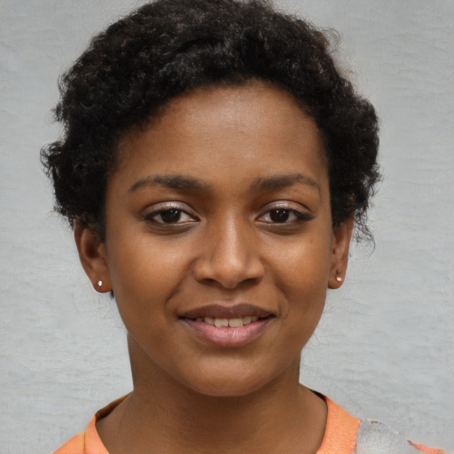 Joyful black young-adult female with short  brown hair and brown eyes
