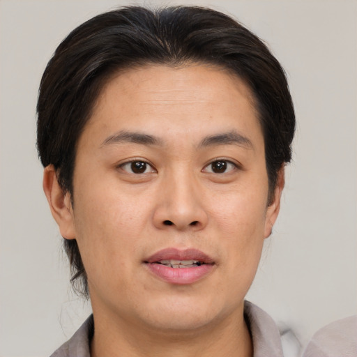 Joyful asian young-adult male with short  brown hair and brown eyes