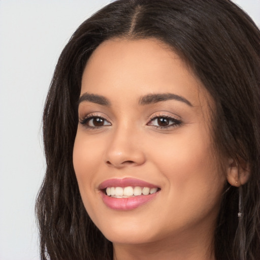 Joyful white young-adult female with long  brown hair and brown eyes