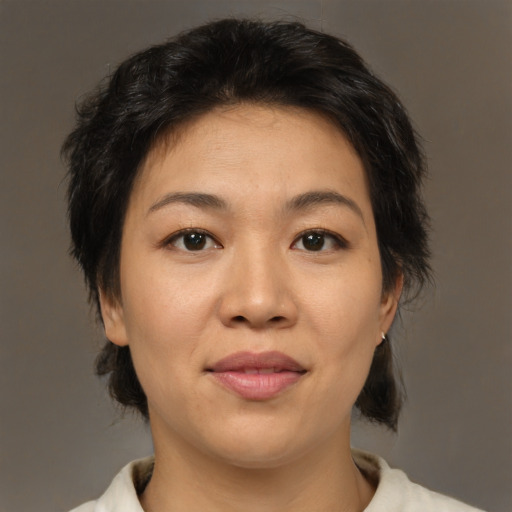 Joyful asian adult female with medium  brown hair and brown eyes