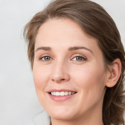 Joyful white young-adult female with medium  brown hair and blue eyes