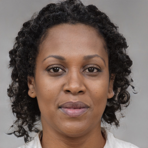 Joyful black adult female with long  brown hair and brown eyes