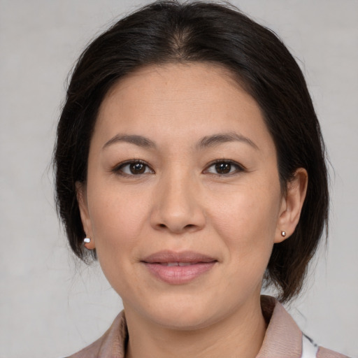 Joyful latino adult female with medium  brown hair and brown eyes