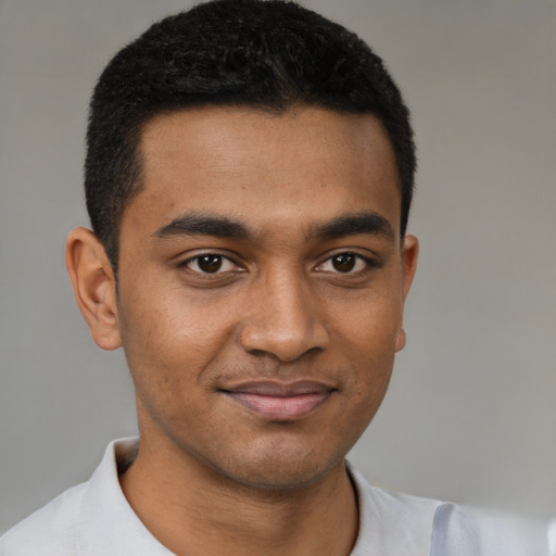 Joyful black young-adult male with short  brown hair and brown eyes