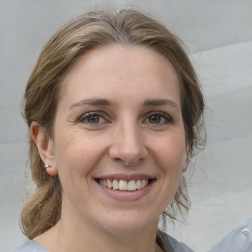 Joyful white young-adult female with medium  brown hair and grey eyes