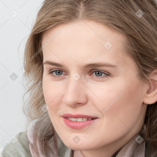 Joyful white young-adult female with long  brown hair and blue eyes