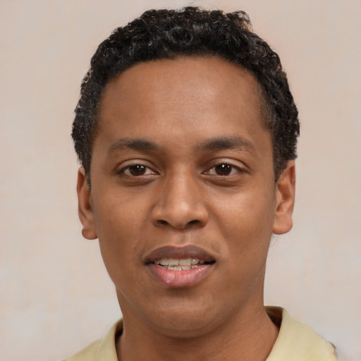 Joyful black young-adult male with short  black hair and brown eyes