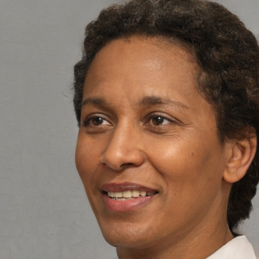 Joyful black adult female with short  brown hair and brown eyes