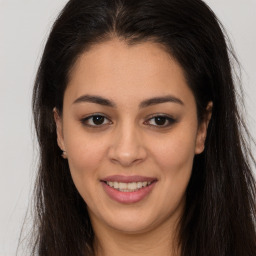 Joyful latino young-adult female with long  brown hair and brown eyes