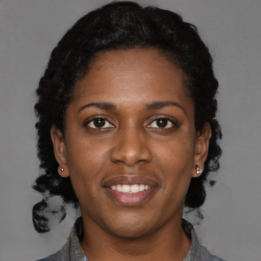 Joyful black young-adult female with medium  black hair and brown eyes