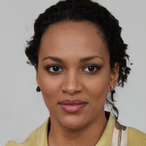 Joyful black young-adult female with short  black hair and brown eyes