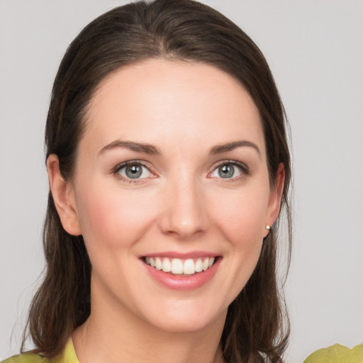 Joyful white young-adult female with medium  brown hair and grey eyes