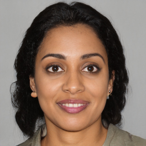 Joyful black young-adult female with medium  black hair and brown eyes