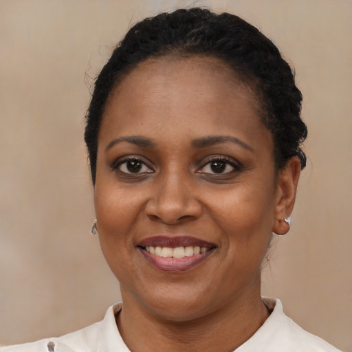 Joyful black adult female with short  black hair and brown eyes