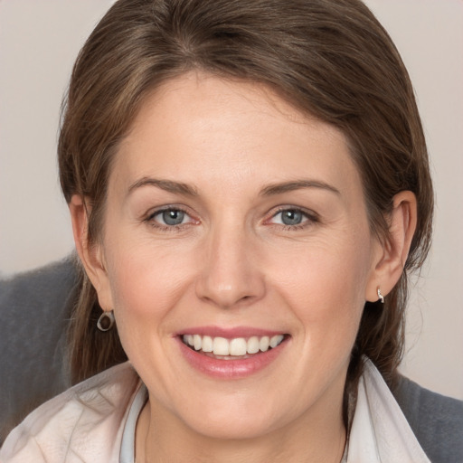 Joyful white young-adult female with medium  brown hair and grey eyes