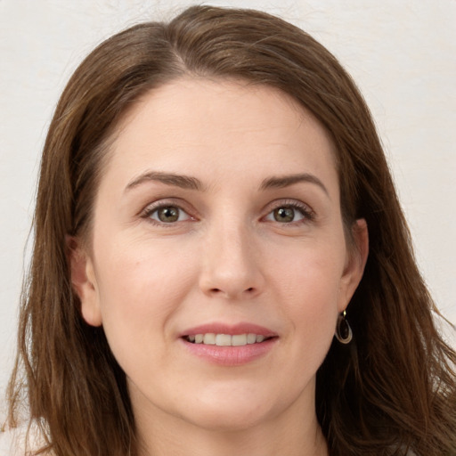 Joyful white young-adult female with long  brown hair and grey eyes