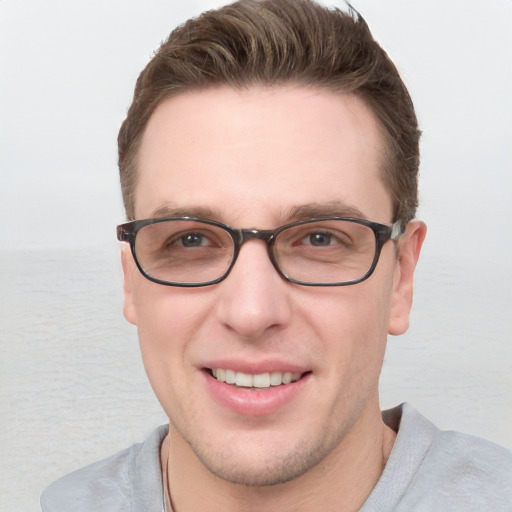 Joyful white young-adult male with short  brown hair and blue eyes