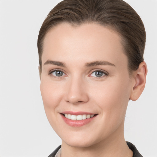 Joyful white young-adult female with medium  brown hair and grey eyes