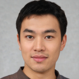 Joyful asian young-adult male with short  black hair and brown eyes