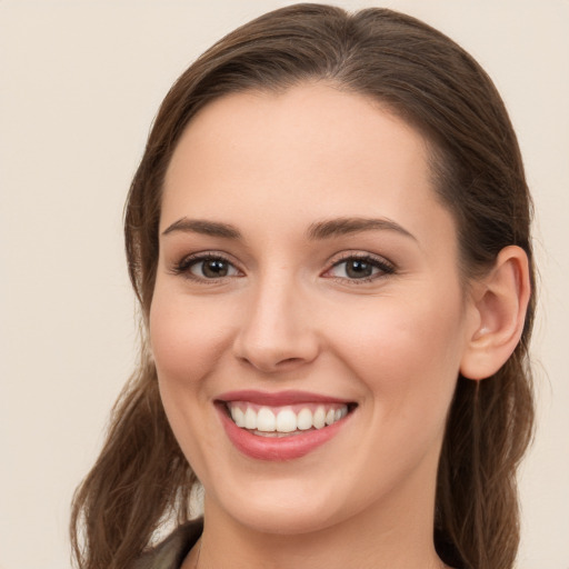 Joyful white young-adult female with long  brown hair and grey eyes