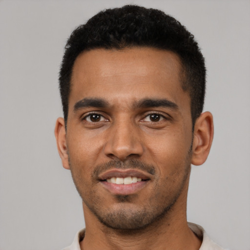 Joyful black young-adult male with short  black hair and brown eyes