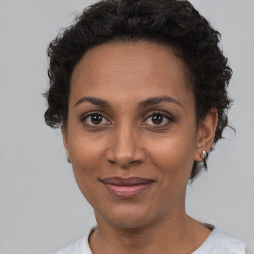 Joyful black young-adult female with short  brown hair and brown eyes