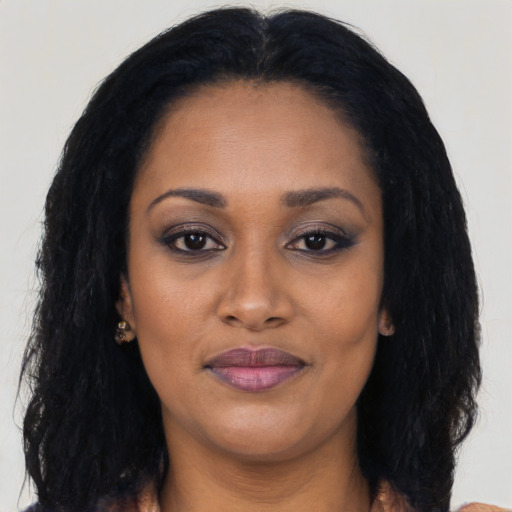 Joyful black young-adult female with long  black hair and brown eyes