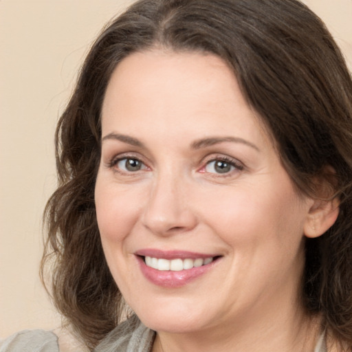 Joyful white adult female with medium  brown hair and brown eyes