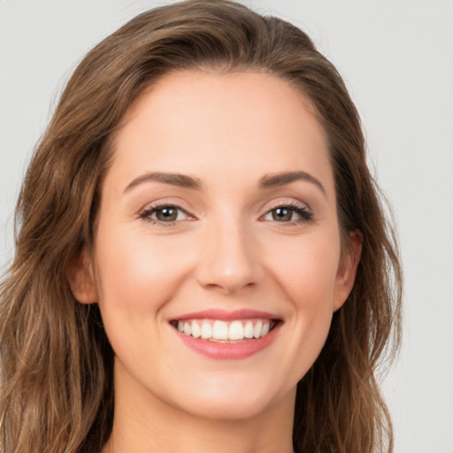 Joyful white young-adult female with long  brown hair and green eyes