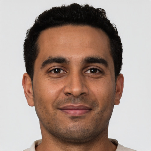 Joyful latino young-adult male with short  black hair and brown eyes