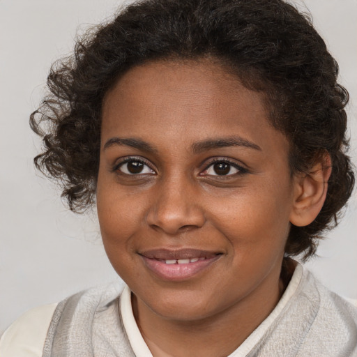 Joyful black young-adult female with medium  brown hair and brown eyes