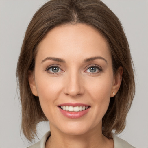 Joyful white young-adult female with medium  brown hair and grey eyes