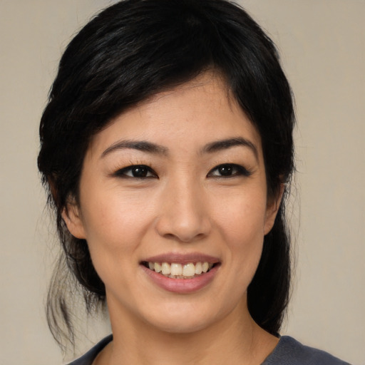 Joyful asian young-adult female with medium  black hair and brown eyes