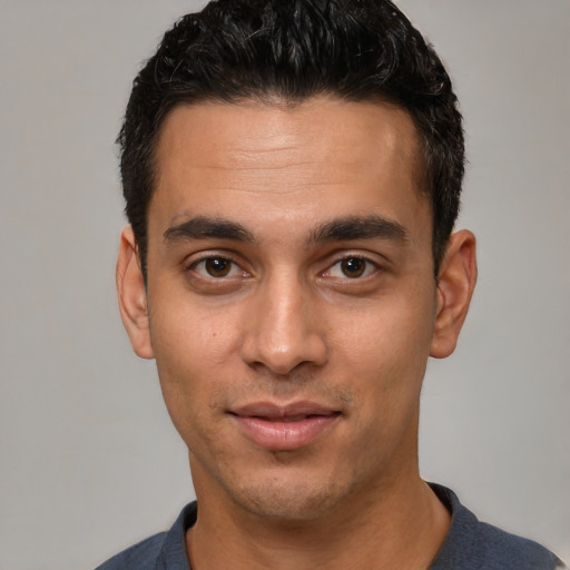 Joyful white young-adult male with short  black hair and brown eyes