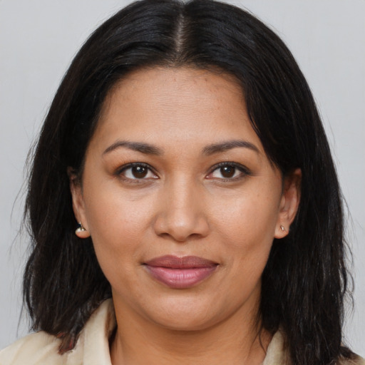 Joyful latino young-adult female with medium  brown hair and brown eyes