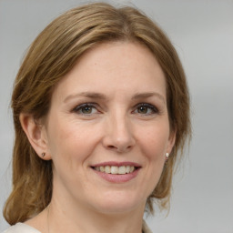 Joyful white adult female with medium  brown hair and grey eyes