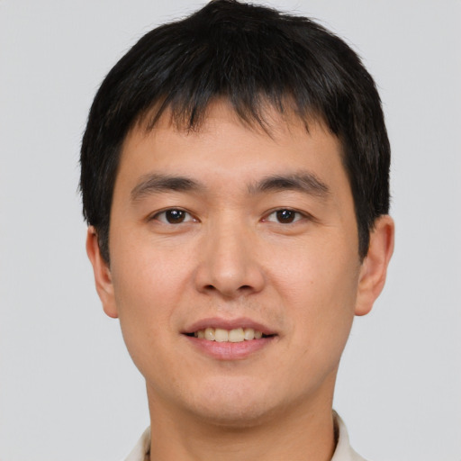 Joyful asian young-adult male with short  brown hair and brown eyes