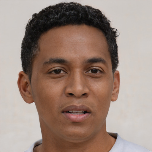 Joyful black young-adult male with short  brown hair and brown eyes