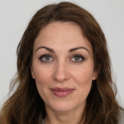 Joyful white adult female with long  brown hair and brown eyes