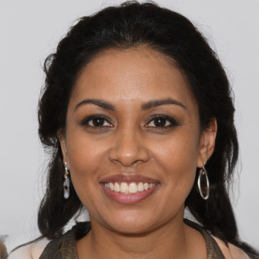 Joyful black young-adult female with long  brown hair and brown eyes