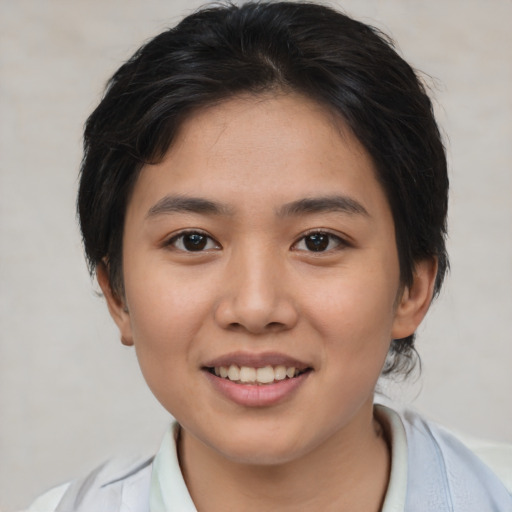Joyful asian young-adult female with short  brown hair and brown eyes