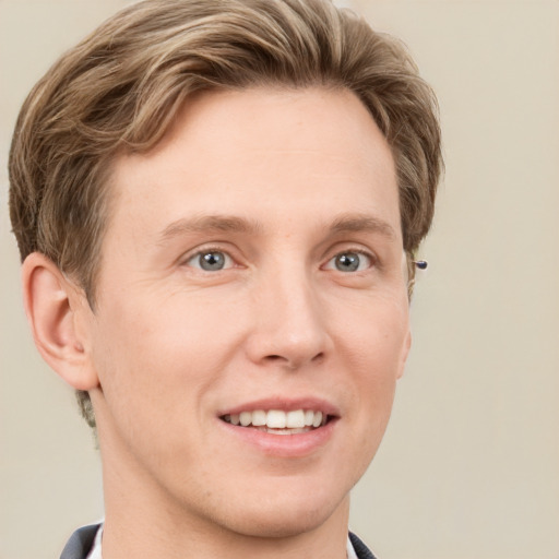 Joyful white young-adult male with short  brown hair and grey eyes