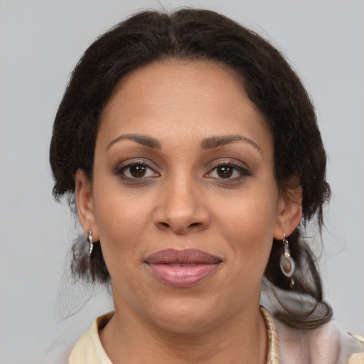 Joyful black adult female with medium  brown hair and brown eyes