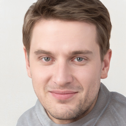 Joyful white young-adult male with short  brown hair and grey eyes